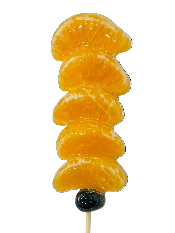 Mandarin orange tanghulu skewer with glassy crystal glaze on a pale blue background